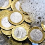 Gold coins in soapy water